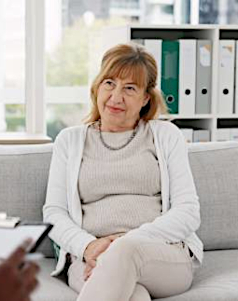 woman sitting on coach listening to the person seated across from her